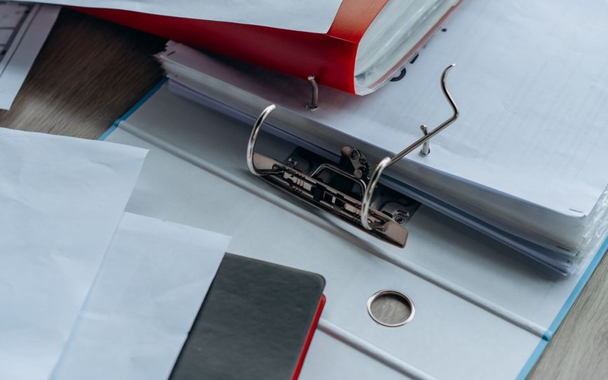 Aufgeräumter Schreibtisch mit Ordnern, Papier und Büroartikeln, ideal für Büro und Bildung.